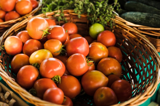 Cesta de mimbre de tomate rojo orgánico en el mercado de la tienda de comestibles