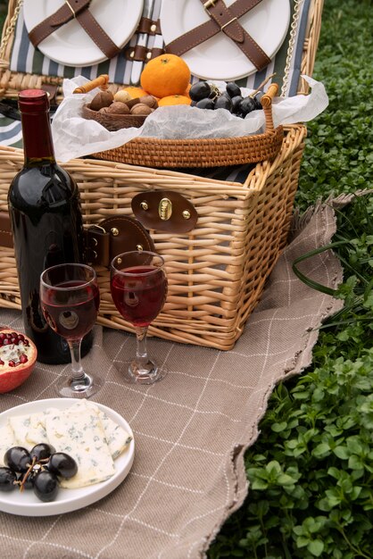 Cesta de picnic de alto ángulo con frutas y vino.