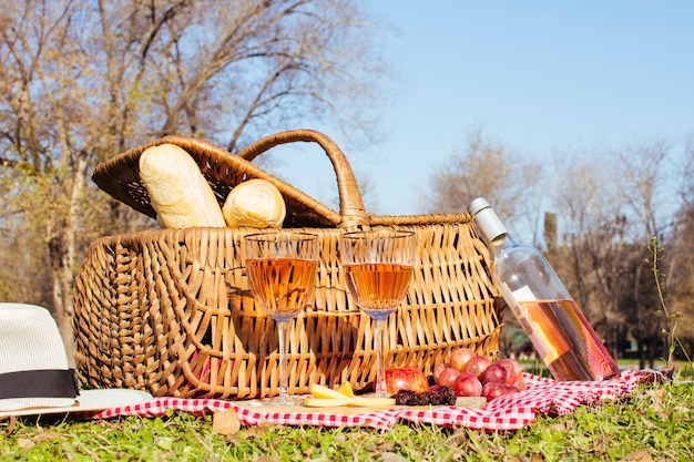 Cesta de picnic con botella de vino blanco.