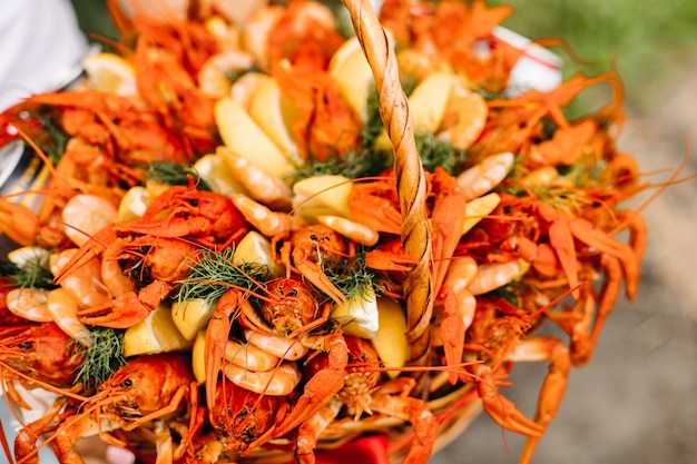 Cesta de regalo tejida festiva para hombre con cangrejos de río y limones