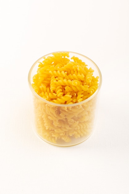 Foto gratuita una cesta de vista frontal con pasta seca pasta amarilla italiana dentro de un recipiente de plástico transparente en el blanco