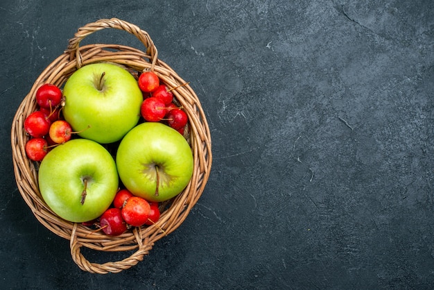 Cesta de la vista superior con frutas manzanas y cerezas dulces sobre fondo oscuro frutas baya composición frescura planta de árbol