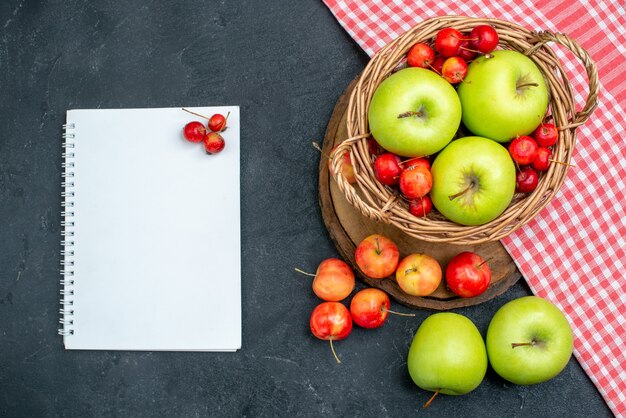 Cesta de la vista superior con frutas manzanas verdes y cerezas dulces en la superficie gris oscuro árbol de frescura de composición de bayas de frutas