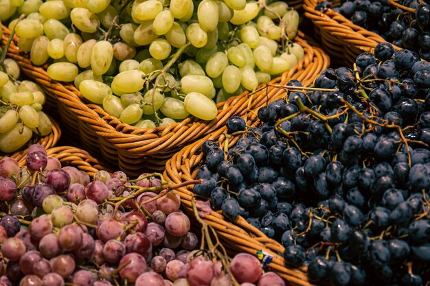 Cestas con diferentes tipos de uvas en el escaparate de un supermercado