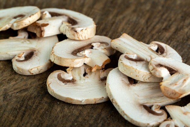 Champiñones blancos rebanados en el escritorio de madera marrón