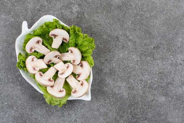 Champiñones picados con verduras en la placa blanca.