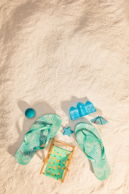 Chanclas y juguetes de arena en la playa