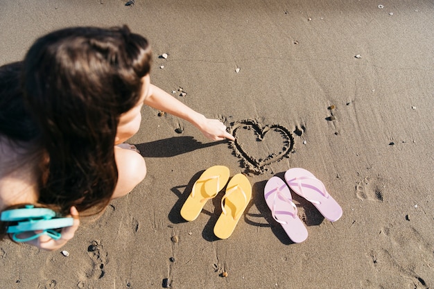 Chanclas y mujer en la playa