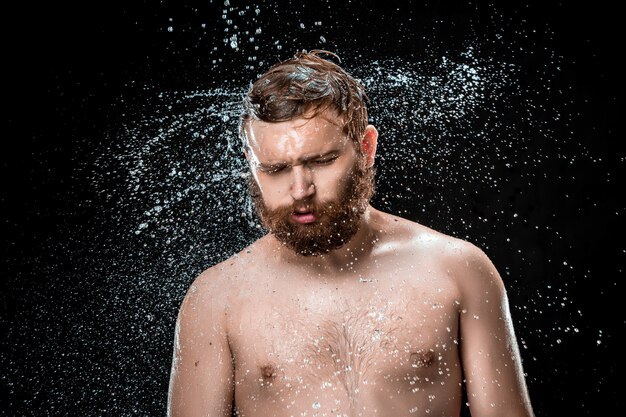 El chapoteo del agua en la cara masculina