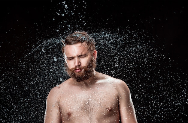 El chapoteo del agua en la cara masculina