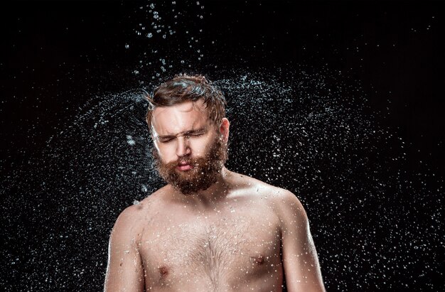 El chapoteo del agua en la cara masculina