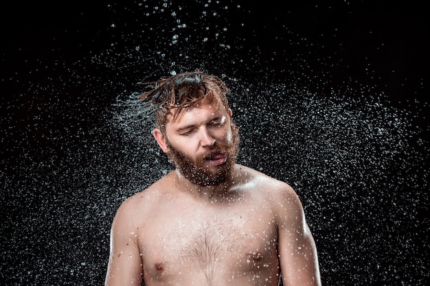 Foto gratuita el chapoteo del agua en la cara masculina