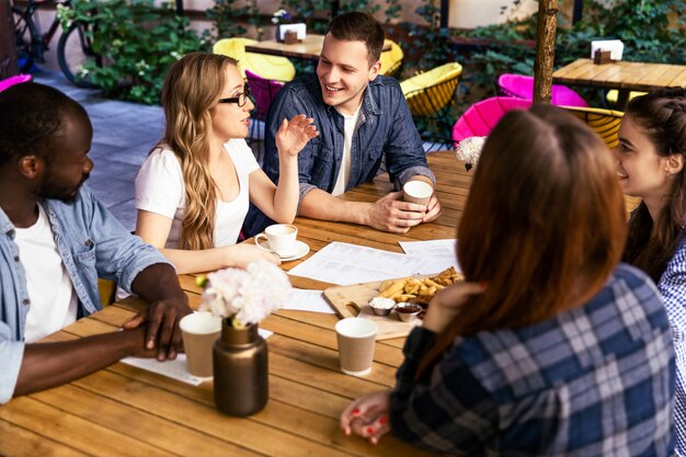 Charla informal con amigos en una reunión semanal en la cafetería local en un caluroso día de verano