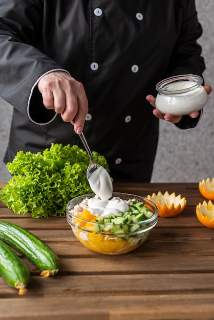 Chef agregando aderezo a la ensalada