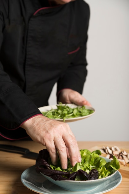 Chef de alto ángulo cocinando ensalada