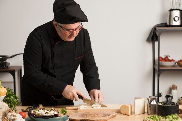 Chef de alto ángulo en ingredientes de corte de cocina