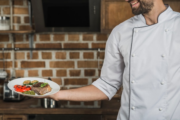 Foto gratuita chef celebración plato preparado para servir en el restaurante