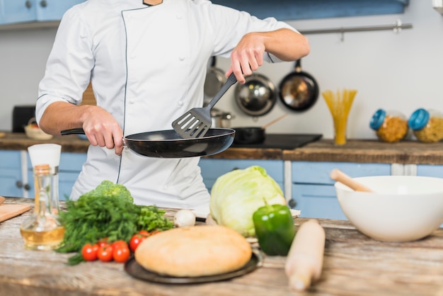 Chef en cocina cocinando con verduras