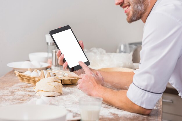 Chef en cocina con plantilla de pantalla de tableta