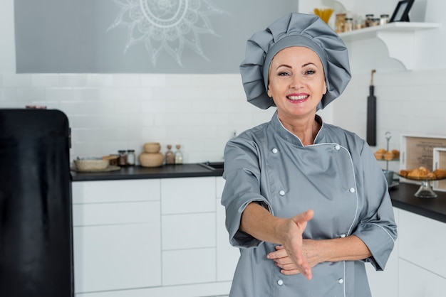 Chef en cocina preparado para estrecharle la mano