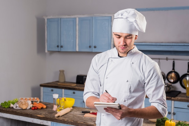 Chef en cocina tomando notas