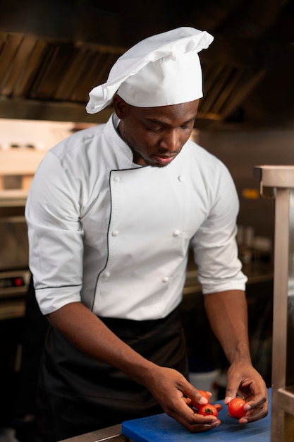 Foto gratuita chef cocinando en la cocina mientras lleva ropa profesional