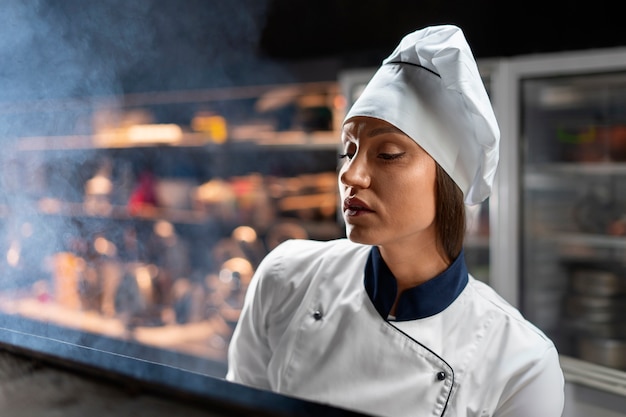 Foto gratuita chef cocinando en la cocina mientras lleva ropa profesional