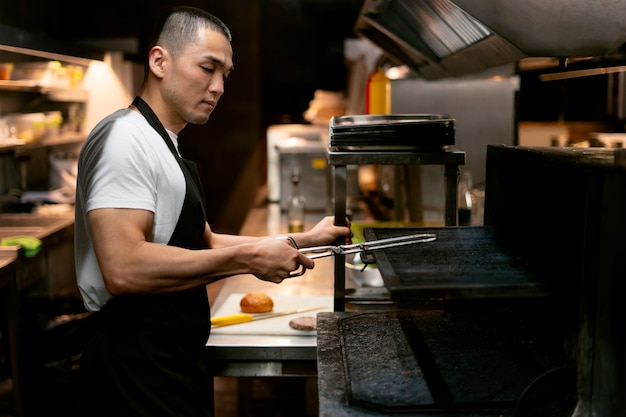 Foto gratuita chef cocinando en la cocina mientras lleva ropa profesional