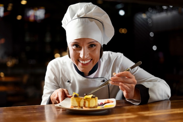 Foto gratuita chef cocinando en la cocina mientras lleva ropa profesional