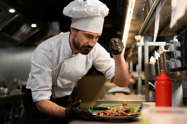 Chef cocinando en la cocina mientras lleva ropa profesional