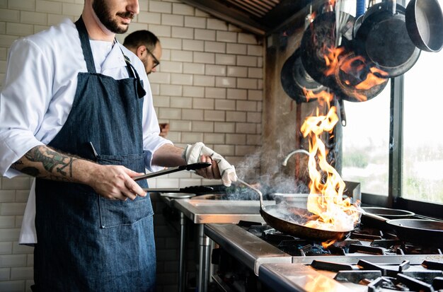 Chef cocinando comida en la cocina del restaurante