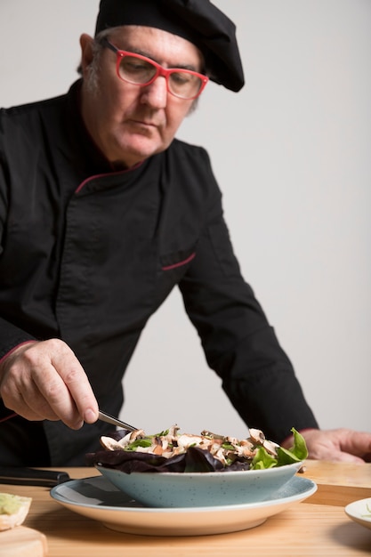 Chef cocinando ensalada con champiñones