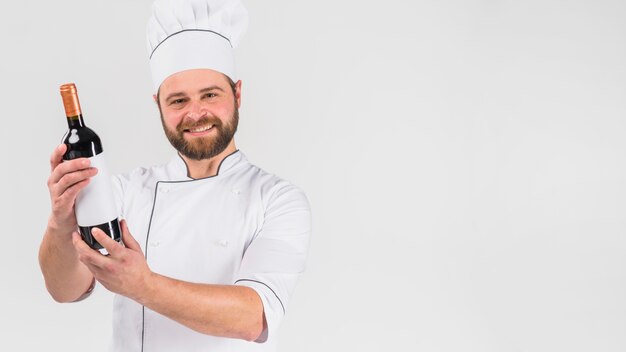 Chef cocinero mostrando botella de vino