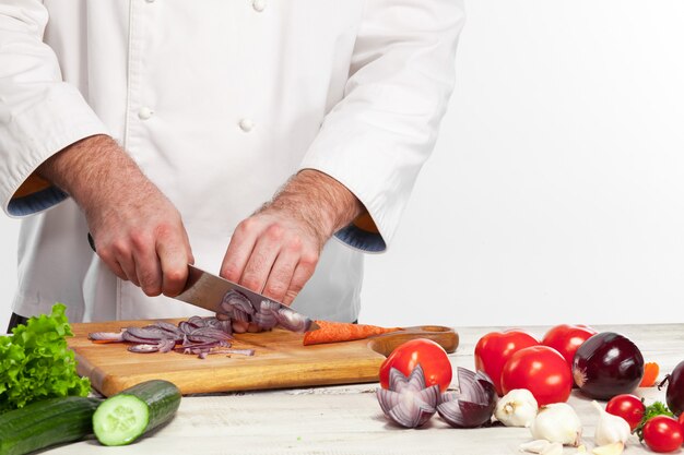 Chef cortando una cebolla en su cocina