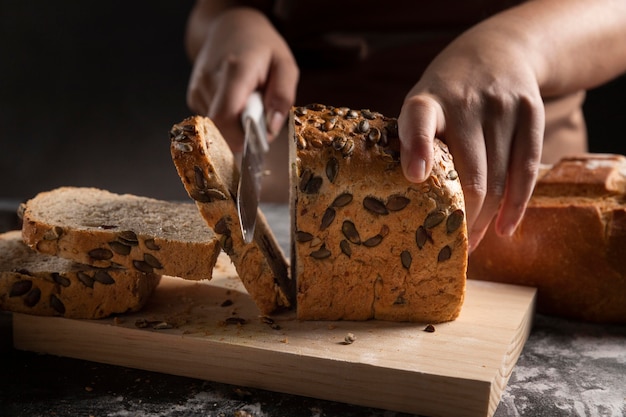 Foto gratuita chef cortando pan horneado con cuchillo