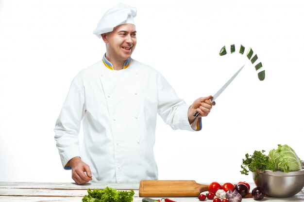 Chef cortando un pepino verde en su cocina