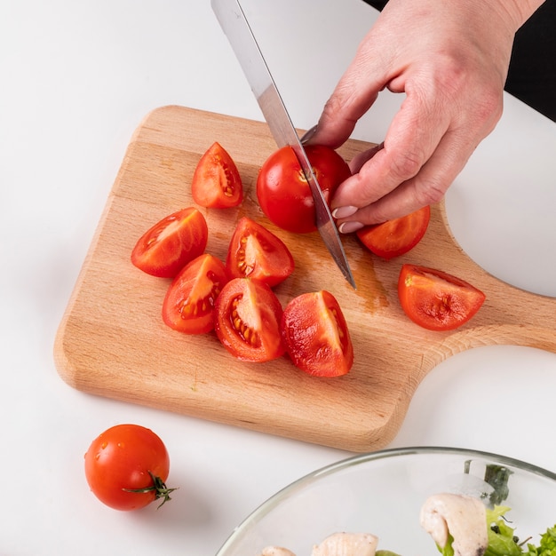 Chef cortando tomates frescos