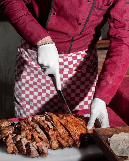 chef cortando en trozos filete de cordero a la parrilla