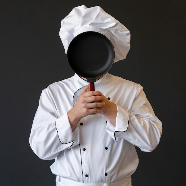 Chef cubriendo la cara con sartén