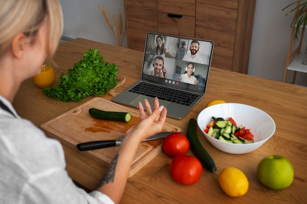 Foto gratuita chef femenina teniendo una videollamada mientras cocina