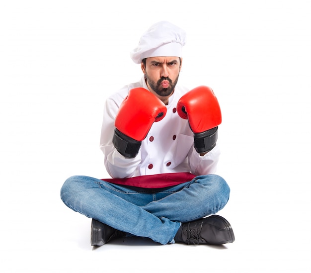 Foto gratuita chef con guantes de boxeo sentado en el suelo