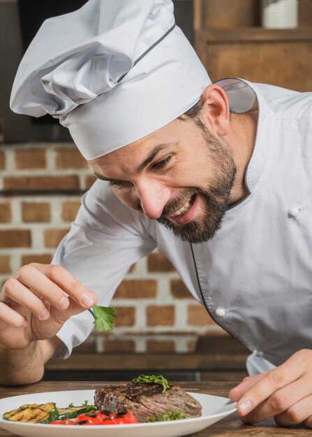 Chef guarnición de su plato con hojas de cilantro