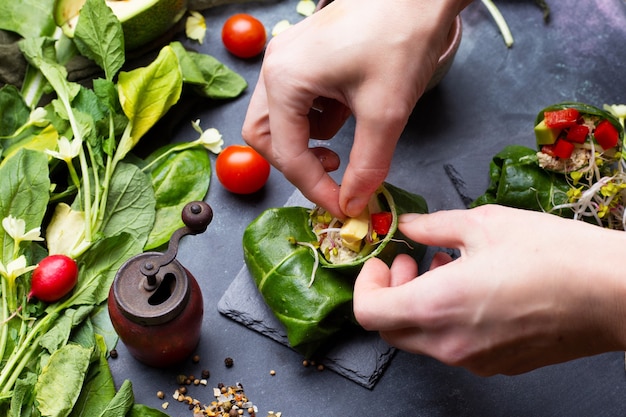 Chef haciendo una envoltura vegana con pimientos rojos y tomates