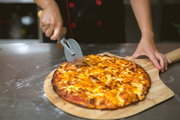 Foto gratuita chef haciendo pizza en la cocina