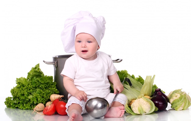 Chef lindo bebé con olla grande y verduras