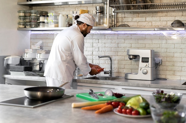 Chef masculino en la cocina cocinando un plato en una sartén