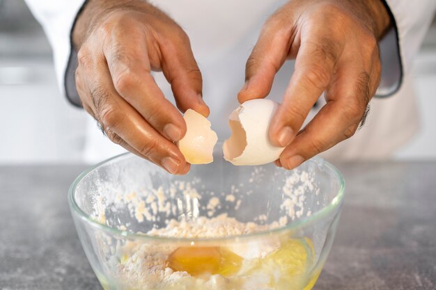 Chef masculino en la cocina usando huevos para cocinar