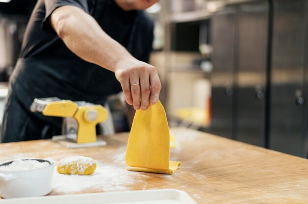 Chef masculino con delantal y masa de pasta fresca