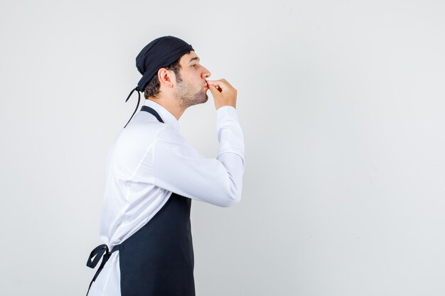 Chef masculino haciendo delicioso gesto en uniforme, delantal.