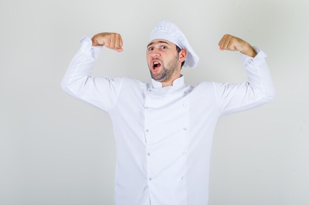 Chef masculino mostrando sus músculos en uniforme blanco y luciendo fuerte